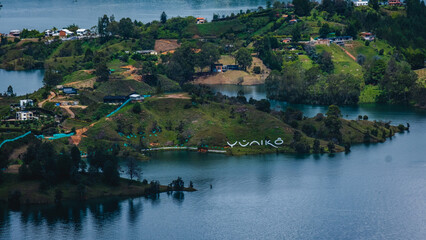 Fototapeta na wymiar Aerial Drone Top Notch Flying Above Guatape Roads Village Lake and Islands Day Light near Medellin Colombia Misty Morning light over Houses