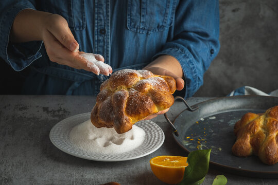 Woman preparing Pan de muertos bread of the dead for Mexican day of the dead