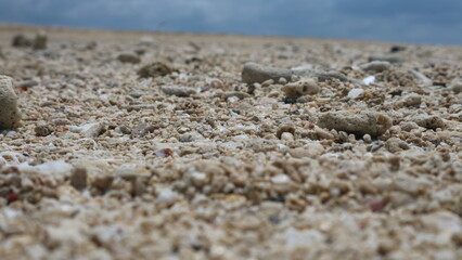 Sand and rocks by the beach against a backdrop of blue sky and soft white clouds. great for backgrounds and wallpapers