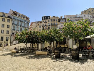 Outdoor cafe on an old world cobblestone street on a sunny afternoon in Lisbon Portugal