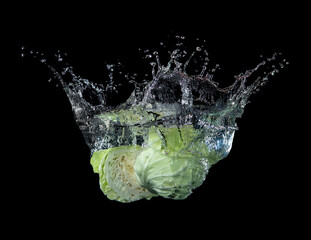 Head of lettuce with water splash isolated on black background,lettuce washing