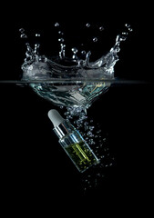 Glass bottle of anti aging serum splashing into water on black background,Cosmetic for skin care - obrazy, fototapety, plakaty