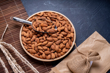 Roasted Delicious Almond on brown wooden table, Almond in wooden plate on wooden table.