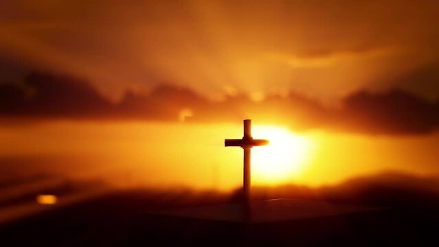 The bright red sky and the rays of light shining through the flowing clouds and the silhouette of the holy cross symbolizing the suffering, death and resurrection of Jesus Christ

