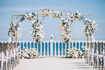 Wedding ceremony on the beach. Wedding arch made of natural flowers.