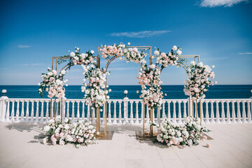 Wedding ceremony on the beach. Wedding arch made of natural flowers.