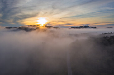 Aerial view Beautiful  panorama of morning scenery Golden light sunrise And the mist flows on high mountains forest. Pang Puai, Mae Moh, Lampang, Thailand.