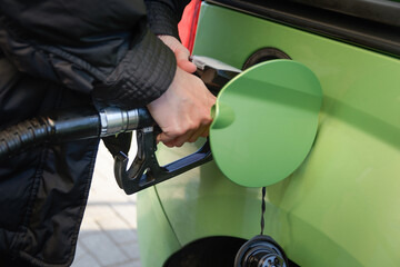 Filling up the car. In a gas station, a woman fills her gas tank