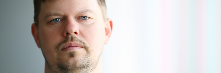 Fototapeta premium Portrait of young sad man in front of window