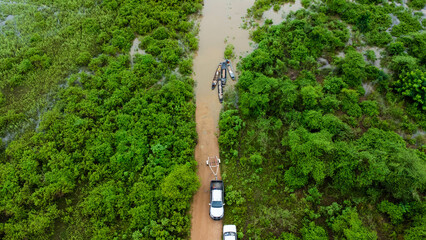 Aerial view of longtail boats in a green meadow is affected by flooding in the rainy season. Top...