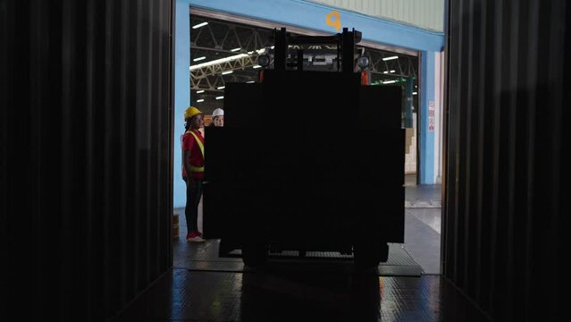 Forklift driver loading a shipping cargo container pallet with cardboard boxes in warehouse. International import and export business concept.