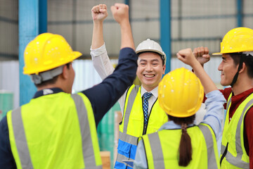 Group of technician engineer and businessman in protective uniform with hardhat standing and raising hands celebrate successful together or completed deal commitment at industry manufacturing factory