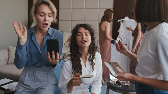 Slow motion of professional wedding planner and make up artist working with beautiful bride in morning,