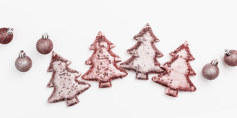 Christmas decorations, shining pink color toys in shape Christmas fir tree from sequins on white...