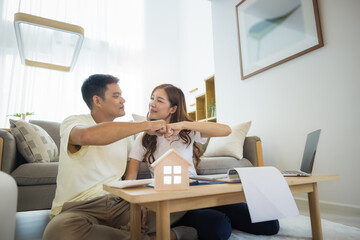 Asian couple in home or house. To bump punch, compare prices, interest, credit and calculate...