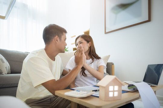 Asian couple in home or house. To compare prices, interest, credit. Include laptop, calculator and document on table. Concept for marriage, loan, finance, insurance, mortgage, real estate and property