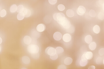 Defocused abstract bokeh background beige pastel colored, flare from lights, beige monochrome photo, blurred round bokeh as holiday fon, celebration wallpaper. Glittering aesthetic pattern