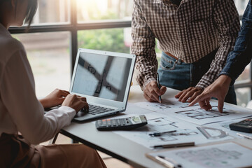 Project planning meeting engineers or architects drawing models working together using laptop computers and engineering tools to create model and blueprints at work.