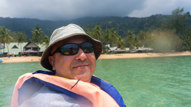 Man in blue and white jacket wearing white cap