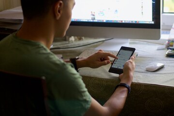 Man sitting on chair while using smartphone