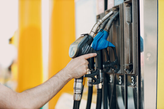 Person Holding Blue And Black Fuel Gun At The Gas Station