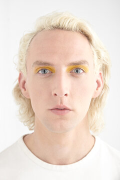 Portrait of blond man wearing orange eye-shadow
