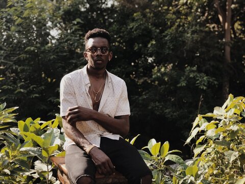 Portrait of brunette man wearing sunglasses and unbuttoned shirt&not;&dagger;