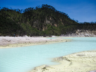 Natural scenery of white crater volcano. The acid lakes shine bright colors ranging from blue,...