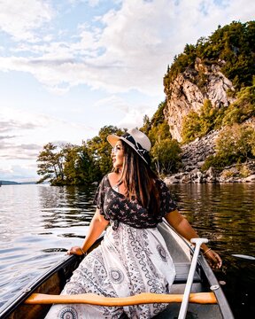 Woman in black and white dress riding boat