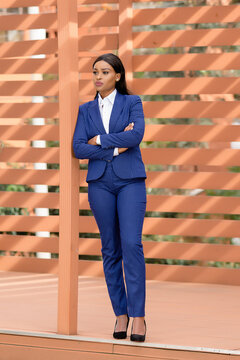 Woman in blue blazer and blue pants standing
