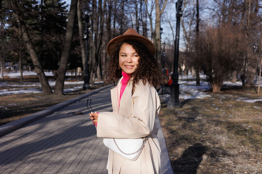 Woman in white coat holding white tote bag