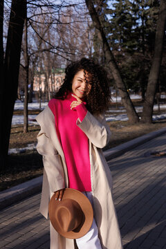 Woman in white coat standing on sidewalk