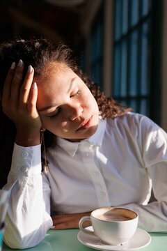 Woman in white dress shirt covering her face