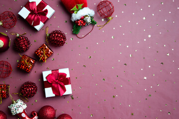 Christmas gift box and ornaments over the red background. 