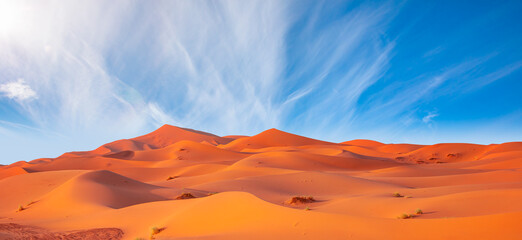 Naklejka na ściany i meble Beautiful sand dunes in the Sahara desert with amazing cloudy sky - Sahara, Morocco