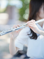 昼の屋外で演奏する女性フルーティスト