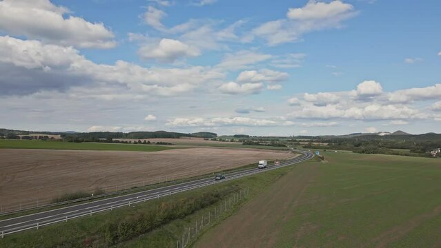 Aerial view of a modern road and passing cars in a picturesque landscape