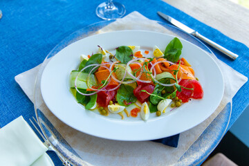 Fish salad with marinated tuna, smoked salmon, vegetables and red caviar