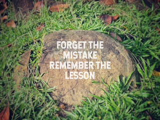 'Forget the mistake remember the lesson' text in vintage background. Inspirational and motivational quote concept. Stock photo.