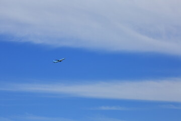 Fototapeta na wymiar 제주도의 푸른하늘을 나는 비행기와 푸른바다를 건너는 배
