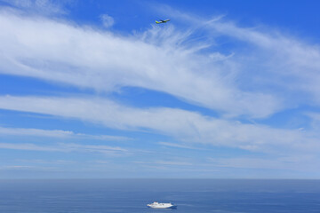 Fototapeta na wymiar 제주도의 푸른하늘을 나는 비행기와 푸른바다를 건너는 배