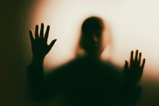 Shadowy figure, child behind glass - horror background