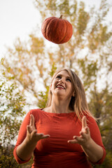 Portrait of beautiful middle-aged blonde woman with pumpkin ready for halloween celebration, mockup for postcard and invitation or advertisement