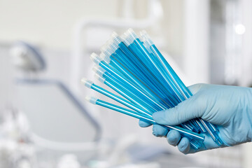 Dentist's hand in glove with saliva ejectors.