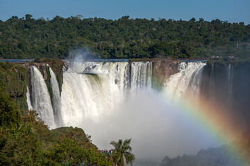 A rainbow forms at the Iguazu Falls looking from the Brazilian side towards Devil's Throat. The Iguazu Falls border both Brazil and Argentina.