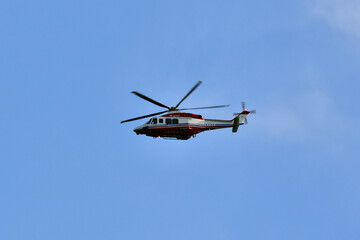 Fototapeta na wymiar 青空を飛ぶ消防のヘリコプタ