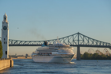 Phoenix cruiseship or cruise ship liner Amera arrival to port Montreal, Canada on sunny day on St. Lawrence River for Indian summer East Coast cruising with downtown skyline, bridge clock tower