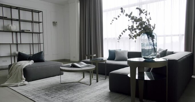 Modern contemporary Minimalist living room with grey furniture. Luxury Modern House Interior With Corner Sofa round table. Fashionable furniture. Cozy Modern Furniture Design. Luxury Elegant Room
