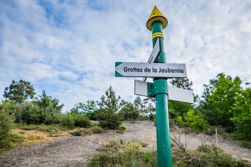 Signs indicating the path to La Jaubernie cave near Coux, Ardeche (South of France)