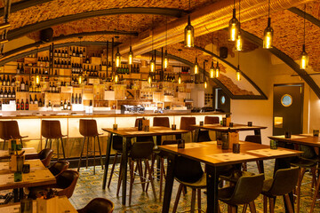 Interior of cozy modern restaurant with a bar counter and lamp lighting